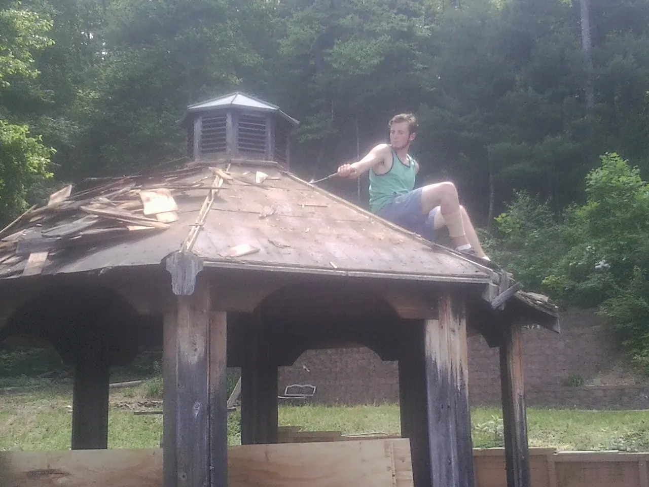 Tearing the old roof off a wooden gazebo before new shakes in West Point