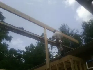 Carpenter setting a ridge beam over a new addition frame — Ice Dam Removal by Roofing Brothers in West Point